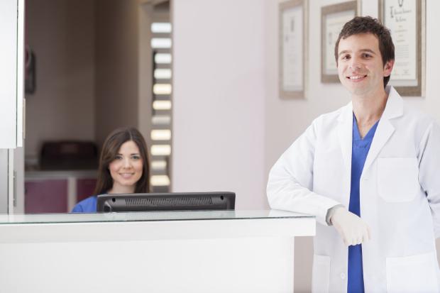 Doctor and receptionist at clean clinic front desk – representing welcoming environment through doctor office scenting